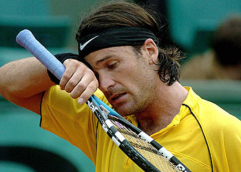 Carlos Moyà se seca el sudor de la frente con aspecto abatido.