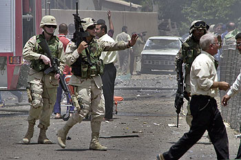 Soldados estadounidenses se dirigen al lugar donde explotó un coche bomba junto a la sede de la Coalición, ayer en Bagdad. rnrn ASSOCIATED PRESS