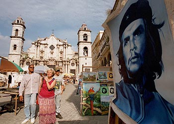 Unos turistas pasan por delante de un cartel de Ernesto  Che  Guevara en La Habana.