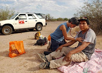 Una voluntaria atiende en Arizona (Estados Unidos) a un emigrante mexicano que sufre deshidratación.