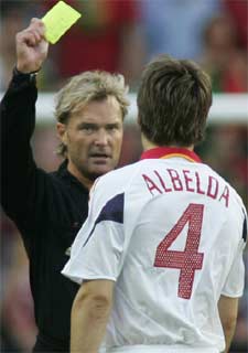 El arbitro, Anders Frisk, muestra la tarjeta amarilla a Albelda.