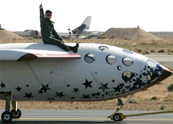 El piloto Mike Melvill saluda triunfalmente en el desierto de Mojave (EE UU) al concluir su histórico vuelo.