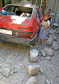 Un niño, delante de su casa tras un ataque con morteros ayer en Mosul.