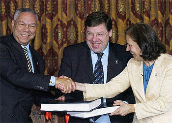 Colin Powell y Loyola de Palacio se saludan en presencia del ministro de Exteriores irlandés.