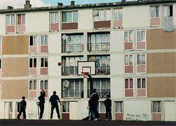 Un grupo de jóvenes juega al baloncesto en un barrio periférico de París.