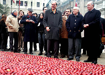 Ricardo Lagos, a la derecha, y el pintor José Balmes, segundo por la derecha, ante el corazón de manzanas rojas instalado frente al Palacio de la Moneda.