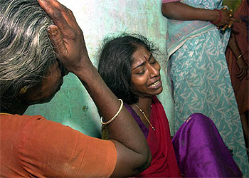 Dos familiares de los niños muertos en el incendio de una escuela de India lloran en el hospital de Kumbakonam.