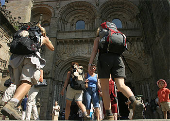 Un grupo de peregrinos se dirige a la puerta románica que da acceso a la catedral de Santiago de Compostela por la plaza de Platerías.