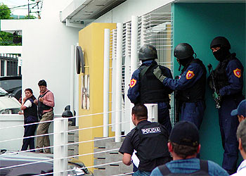 Dos negociadores (izquierda) tratan de comunicarse con el policía que asesinó a tres diplomáticos.