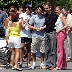 El presidente del Gobierno, acompañado por su esposa, Sonsoles, posan junto a un simpatizante en el puerto de Mahón.