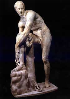  Hermes, atándose una sandalia.   Copia romana en mármol de finales del siglo IV. Museo del Louvre.