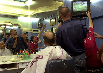 Algunos iraquíes celebran el triunfo en una barbería.