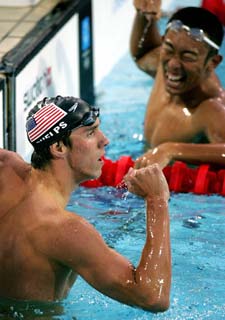 Michael Phelps celebra su título en los 200 metros mariposa con Yamamoto, plata, al fondo.