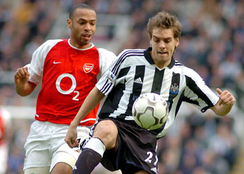 Woodgate controla el balón ante Henry, en un Newcastle-Arsenal de la Liga inglesa.