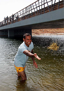 Un operario trata de dejar la  pista  libre de algas.
