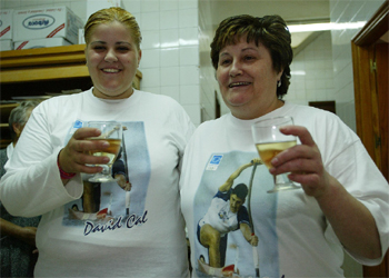 La hermana y la madre de Cal, Paula Cal y María José Figuerosa, brindan por las medallas de David en la panadería que regentan en Cangas de Morrazo.