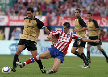 Fernando Sanz y Fernando Torres pelean por el balón.