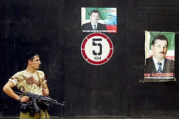 Un policía checheno vigila una calle de Grozni ante un cartel electoral del presidente, Alú Aljánov.