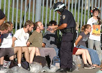 Un policía neoyorquino da de beber agua a un  manifestante detenido durante la conversación republicana.