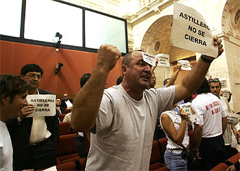 Trabajadores de astilleros increpan al presidente de la Junta durante el pleno. A la izquierda, el coordinador de IU, Diego Valderas.