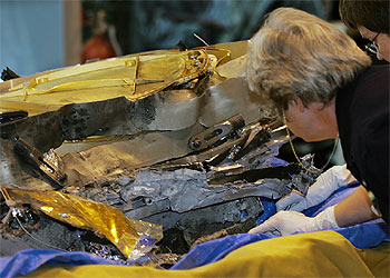 Investigadores de la misión Génesis inspeccionan los restos de la cápsula, entre los que se distinguen apilados algunos colectores.
