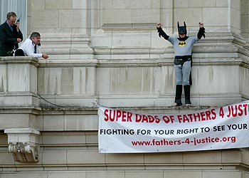 Los servicios de seguridad intentan convencer al reivindicador  Batman  subido a una cornisa.