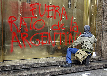 Un miembro de Quebracho hace una pintada contra el director general del FMI, Rodrigo Rato, el pasado 31 de agosto.