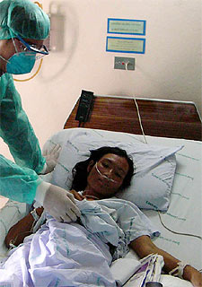 Un médico atiende a la tía de la niña muerta en Tailandia por la gripe aviar.