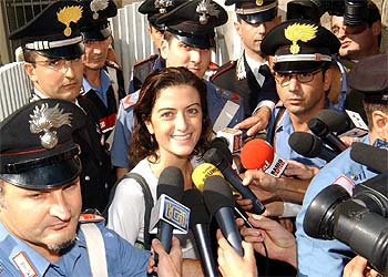 Rodeada de  carabinieri,  Simona Pari habla con la prensa en la puerta de su casa de Roma.
