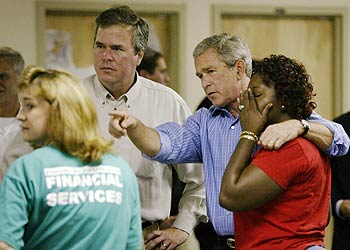 Bush conversa con una de las víctimas del huracán Jeanne en presencia de su hermano Jeb, gobernador de Florida.
