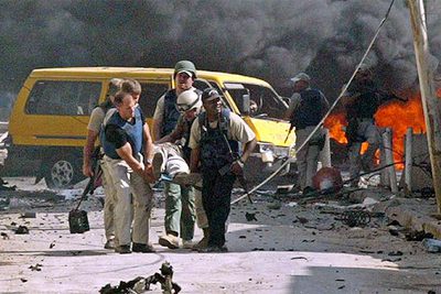 Personal de seguridad traslada a una víctima de un ataque con coche bomba ayer en el centro de Bagdad.