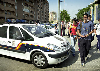 Un coche de la Policía Nacional, ayer a la salida del instituto de Orriols, a cuyas puertas se concentra un grupo que amenaza a estudiantes inmigrantes.