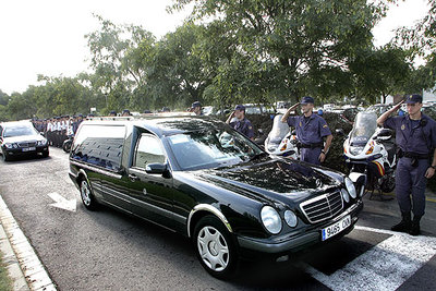 Miembros del Cuerpo Nacional de Policía saludan en L'Hospitalet a los coches fúnebres con los cadáveres de las dos agentes.