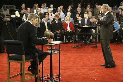 Bush responde a una pregunta de la audiencia mientras Kerry toma notas durante el debate de San Luis.