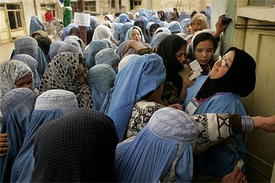 Una funcionaria afgana trata de frenar a un grupo de mujeres que pugnan por entrar en un colegio electoral del centro de Kabul.