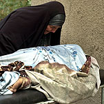 Una mujer iraquí llora sobre el cadáver de su hijo, muerto en uno de los atentados de ayer en Bagdad.