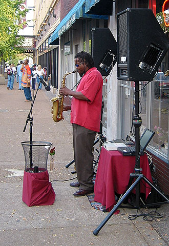 El músico Raven Wolf toca el saxo en el boulevard Delmar de San Luis (Misuri).