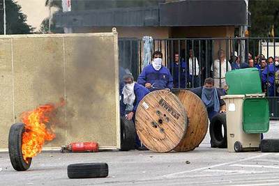 Trabajadores de los astilleros de San Fernando se atrincheraron ayer en las puertas de la factoría, desde donde se enfrentaron a la policía.