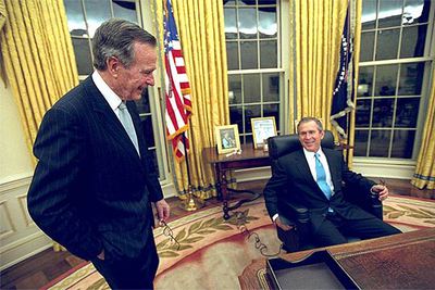 George W. Bush, acompañado de su padre, en su primer día en el Despacho Oval el 20 de enero de 2001.