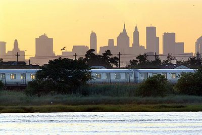 Un tren del metro cruza Jamaica Bay, en Queens, con el perfil de Nueva York al fondo.
