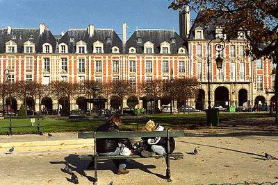 Una pareja de parisienses sentada en un banco de la Place des Vosges.