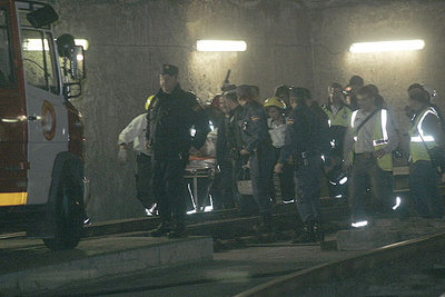 Los servicios de rescate trasladan en camilla al conductor de uno de los convoyes, herido de gravedad en la colisión.