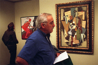 En primer término, un hombre contempla  Nature morte avec lampe,  de Ivan Puni. Al fondo,  Scène de duel,  de Alexandra Exter.