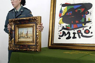 Una agente de la Guardia Civil sostiene el óleo falso de Édouard Manet delante del  miró  auténtico.