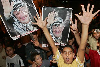 Niños palestinos muestran fotografías de Arafat durante un acto celebrado anoche en la ciudad de Gaza.