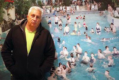 Massimo Vitali posa en la exposición ante su trabajo  De Haan 300 Low-Kiss  (2001).