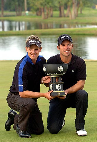 Luke Donald (a la izquierda) y Paul Casey posan, felices, con el trofeo de la Copa del Mundo.