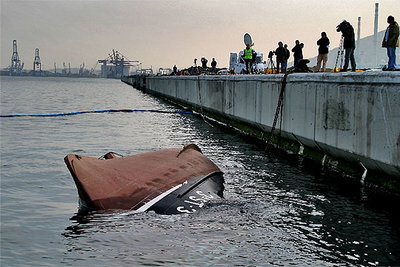 El casco del  Nuevo Pilín  sobresalía ayer del agua junto al muelle de Santurzi, tras voltearse de nuevo.