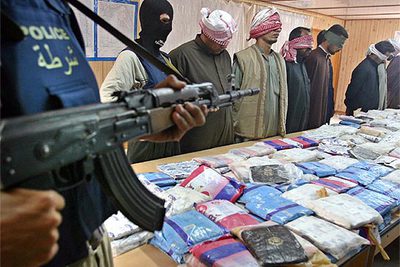 Oficiales de la policía iraquí, con los traficantes y la droga que les confiscaron.