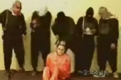 Imagen de un vídeo islamista que muestra al rehén norteamericano Nick Berg. Junto a él, un emascarado armado con un cuchillo hace el gesto de degollarle.